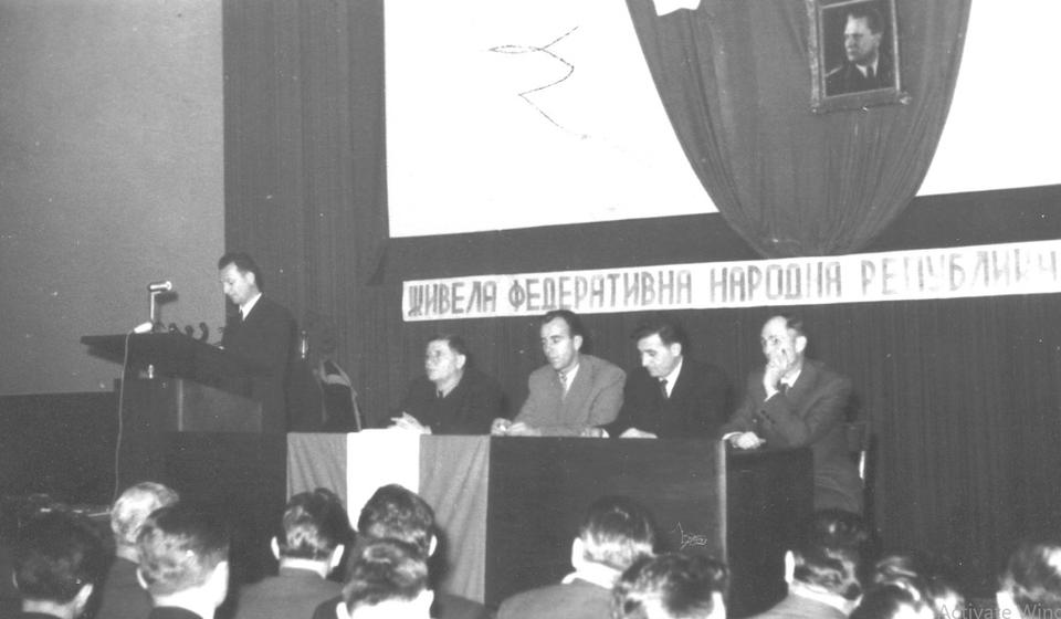 Radno predsedništvo Osnivačke skupštine Radničkog univerziteta održane u Bioskopu Sloboda: za govornicom Raša Mojsilović, sede (s leva na desno) Despot Stevanović, Dobri Cvetković, Đoka Trajković i Atanasije Atanasijević. Foto NU